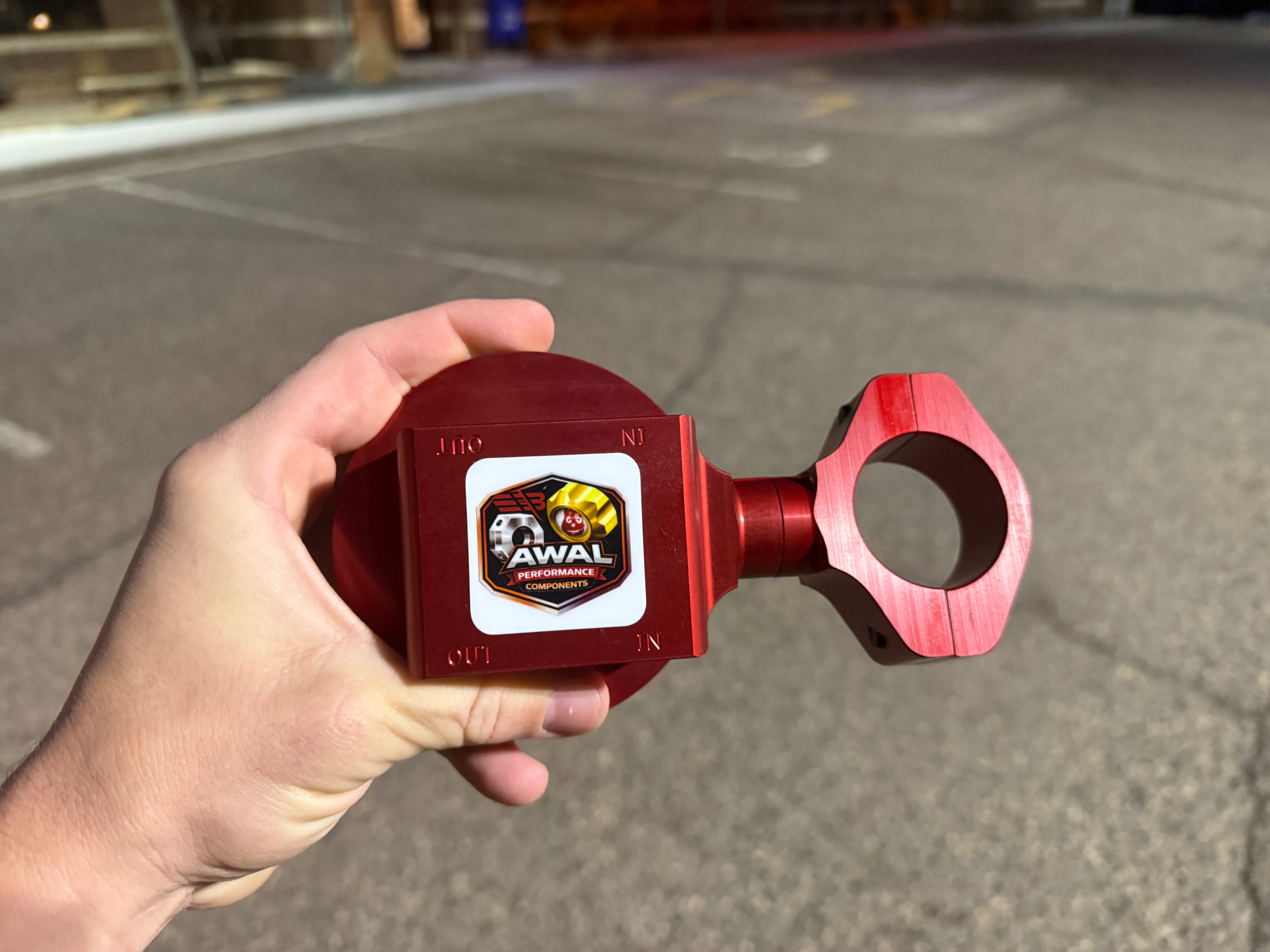Red anodized AWAL Performance Components weight clamp held in hand